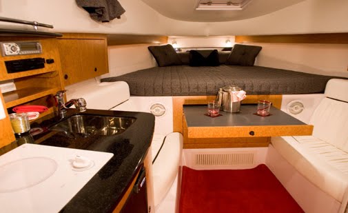 Camarote interior de la Donzi 38 con litera, cocina equipada y área de comedor para rentas de lujo en Cancún