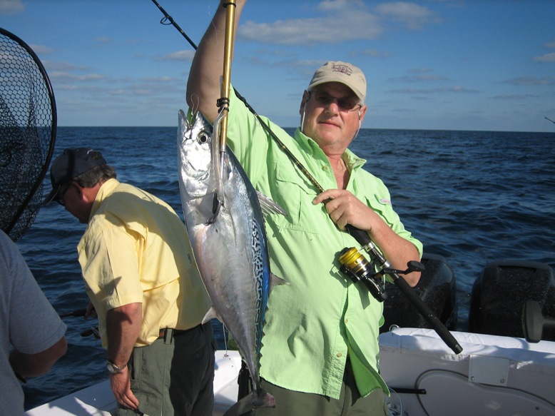 Pescador sosteniendo un gran atún del Caribe capturado en tour de pesca deportiva desde Cancún a bordo de la Donzi 38