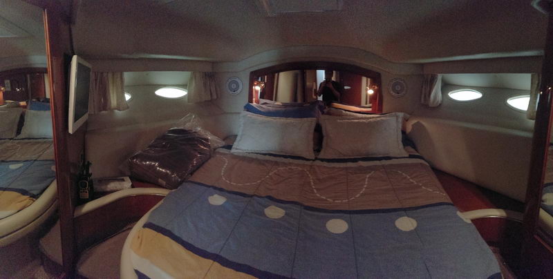 Master cabin of 41 ft Sea Ray flybridge yacht with queen bed, mirror and TV for overnight luxury charter in Cancun