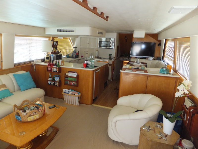 Spacious salon interior of Hatteras 66 ft fishing yacht with fully equipped kitchen, flat screen TV and comfortable lounge seating