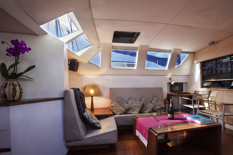 Moderno salón con sofás de cuero, tragaluces y copas de vino a bordo del yate 