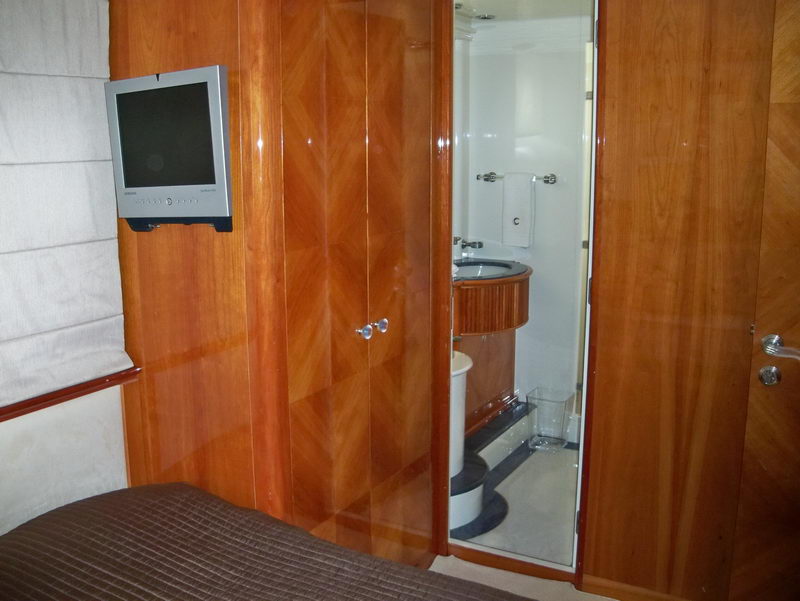 Azimut 100 ft mega yacht stateroom with cherry wood paneling, en-suite bathroom, and flatscreen TV