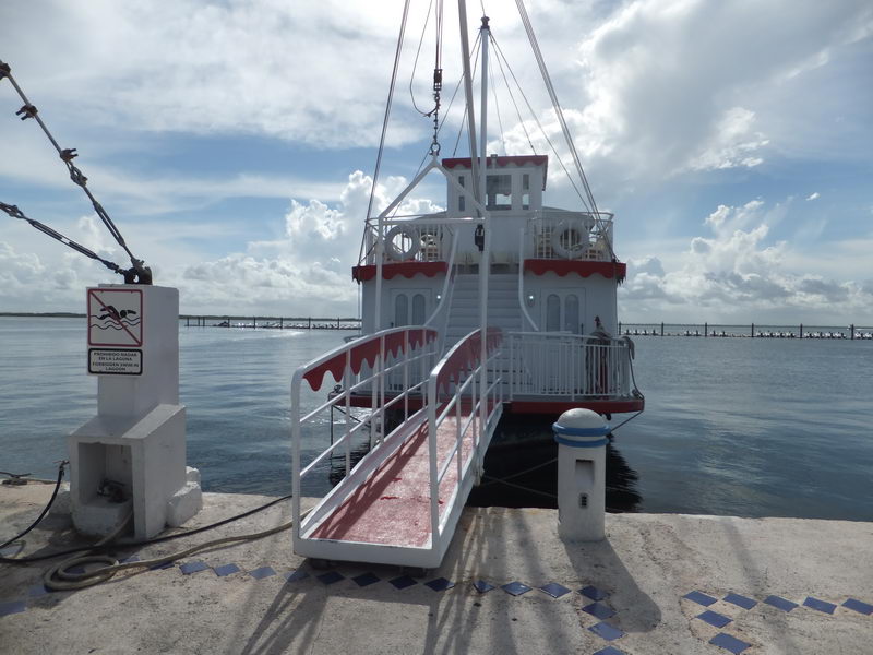 Rampa de abordaje con alfombra roja que lleva al barco de paletas Cancun Queen en su muelle de la Laguna Nichupté, Cancún