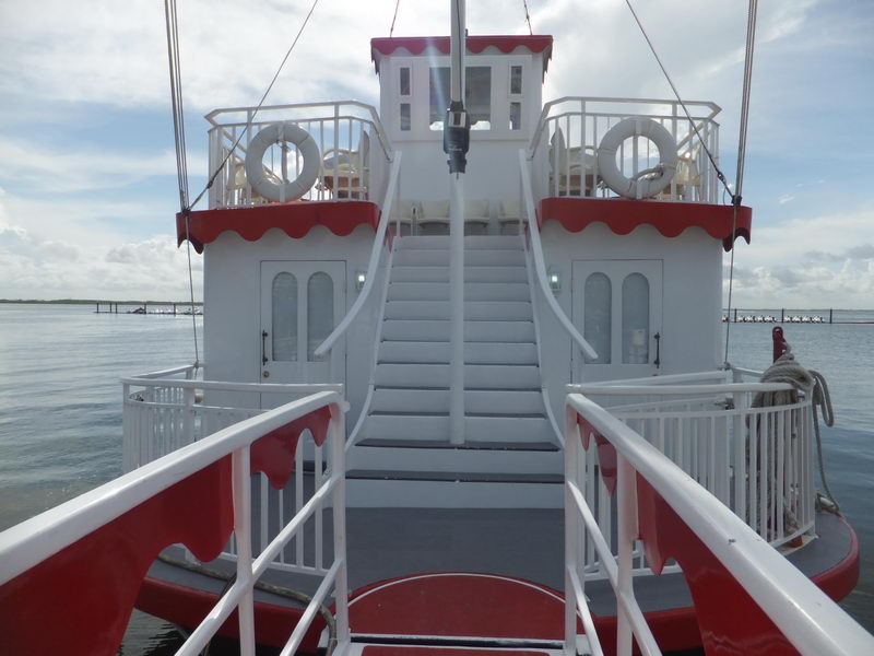Cubierta de proa del Cancun Queen con escalera roja y blanca, salvavidas y asientos al aire libre sobre la laguna de Cancún