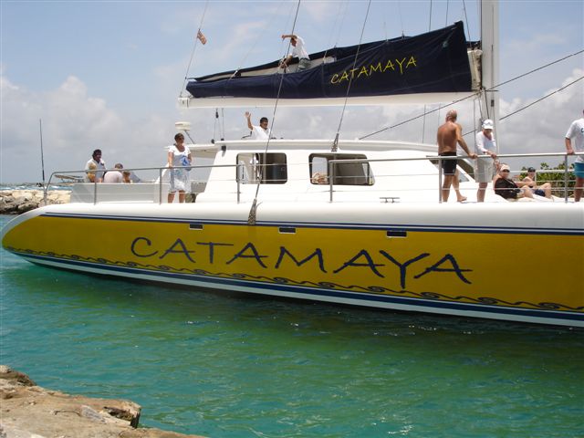 Catamaya catamaran deck view guests relaxing on sailing charter Puerto Aventuras Mexico