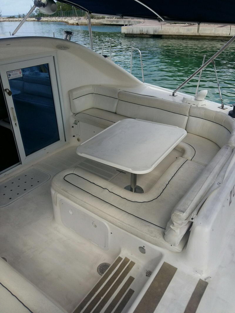 Cockpit dining table and wraparound seating on the Lavezzi 42 catamaran beside turquoise Cozumel water