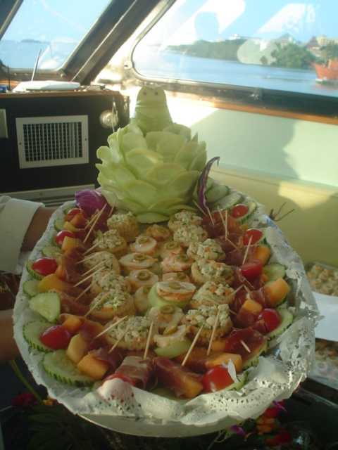 Elaborate canapé platter of shrimp and bite-size hors d'oeuvres with a carved cucumber centerpiece served aboard the Discovery