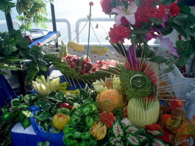 Lavish carved-fruit and flower buffet display set up on the deck of the Discovery boat overlooking the sea