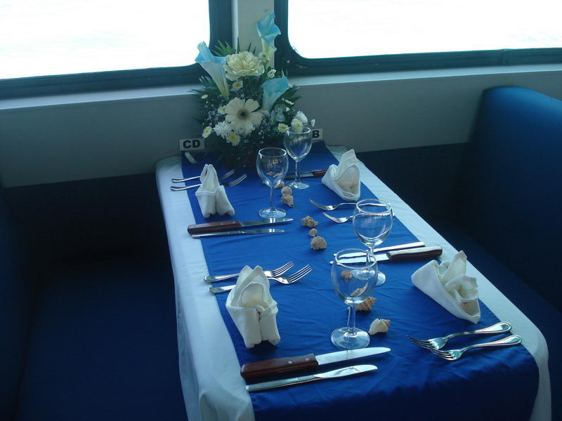 Wedding table detail on the Discovery boat with blue linen, white floral centerpiece and place settings
