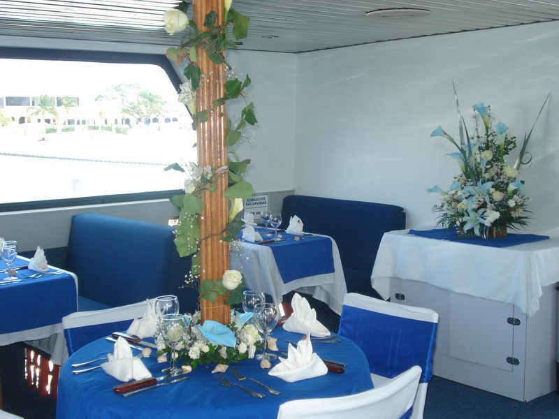 Decorated wedding reception aboard the Discovery boat with draped chairs and ocean light through the windows