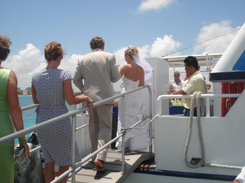 Wedding party gathered on the white-sand beach and pier before boarding the Discovery boat in Cancun