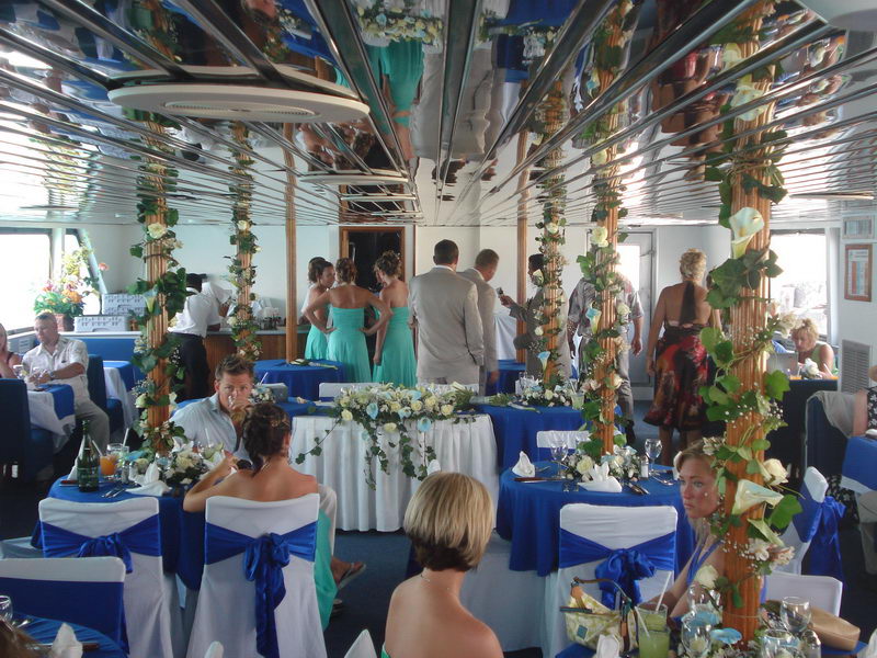 Wedding ceremony setup with chairs and floral arch on the Discovery boat overlooking the turquoise sea