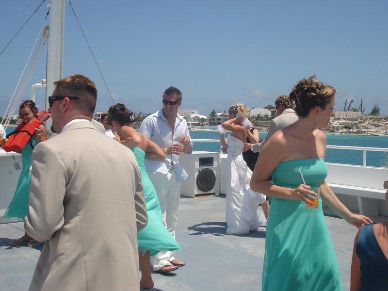 Couple and guests during a wedding ceremony on the deck of the Discovery boat off Cancun