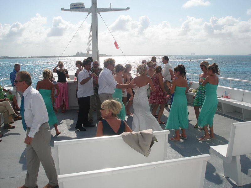 Festive wedding reception moment aboard the Discovery boat with blue linens and floral details