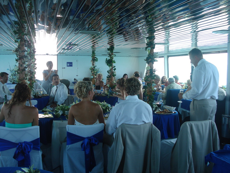 Elegantly decorated wedding reception tables with blue and white linens aboard the Discovery boat in Cancun