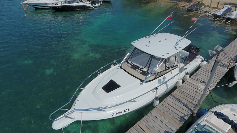 fishing boat tied to a wooden dock over shallow turquoise reef water near Cancun