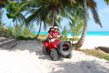 Riders on ATV four-wheelers exploring a sandy beach and jungle trail near Cancun