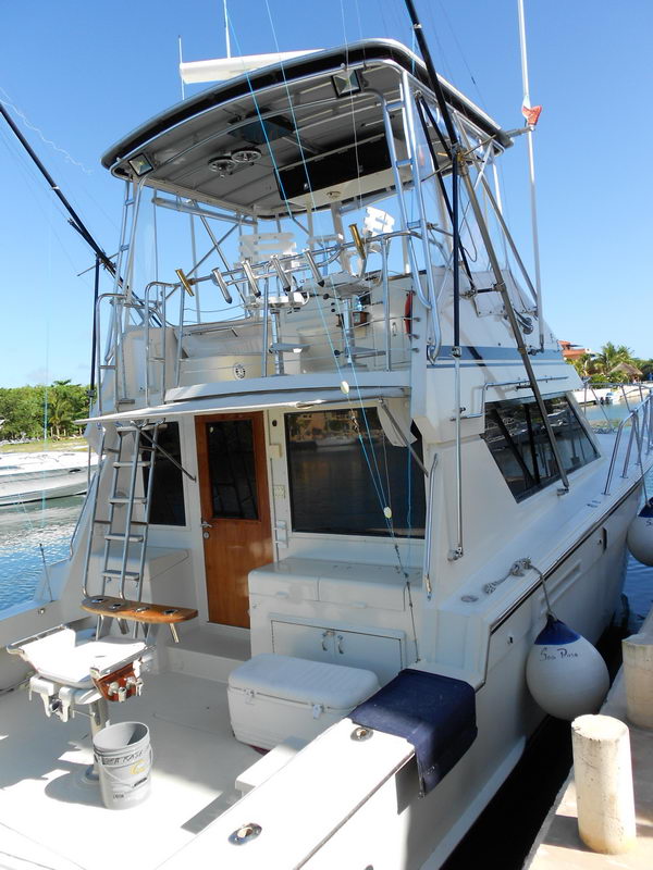 45 ft Hatteras sportfishing yacht stern with flybridge, tuna tower and fighting chair docked at Puerto Aventuras marina Riviera Maya