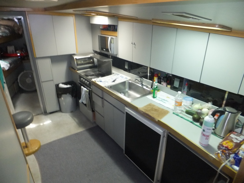 Full galley with stove, microwave and sink aboard the 50 ft Hatteras fishing yacht charter based in Puerto Aventuras Riviera Maya