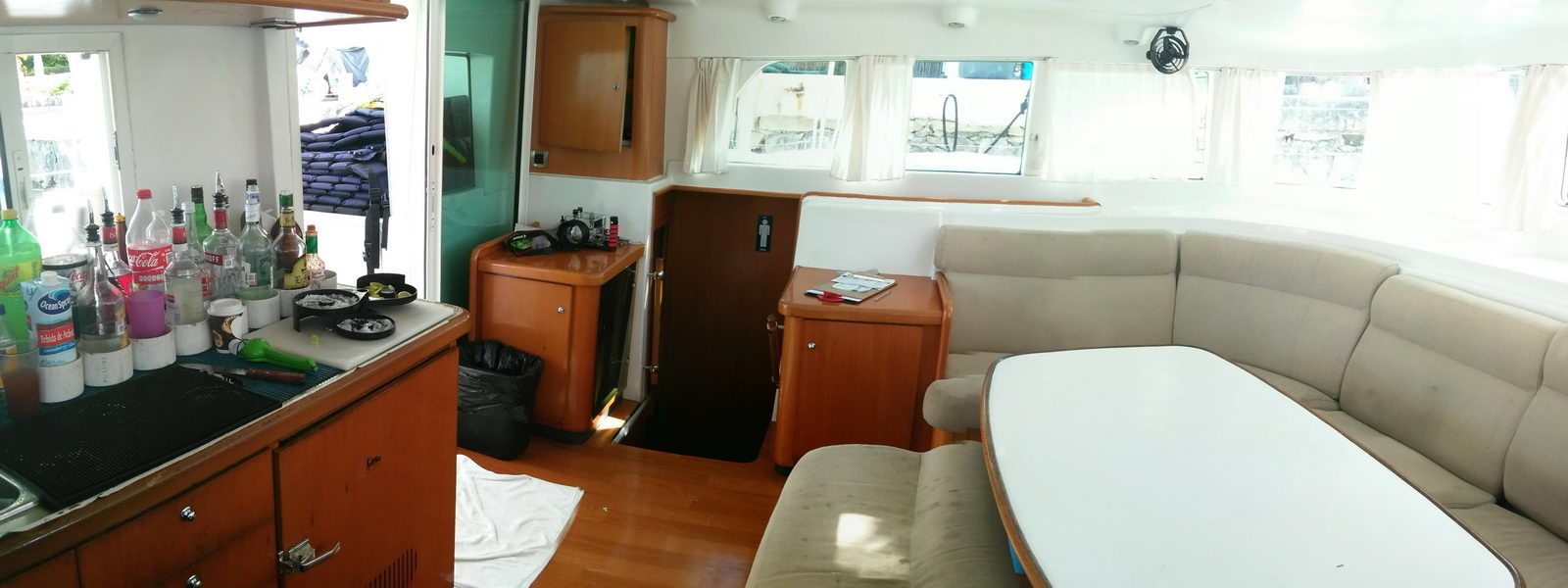 Panoramic salon of the Lagoon 440 catamaran with wraparound lounge, dining table and stocked bar for a Puerto Aventuras charter