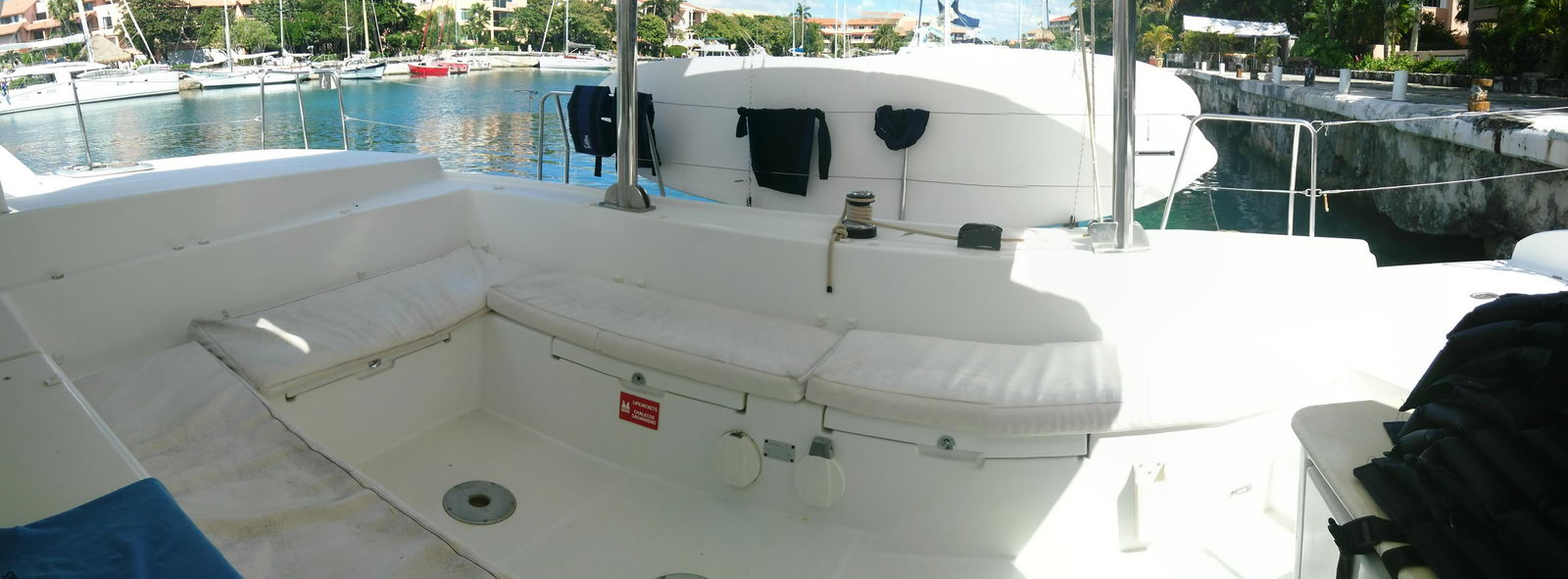 Cockpit seating of the Lagoon 440 catamaran with cushioned benches overlooking Puerto Aventuras marina and sailboats Riviera Maya