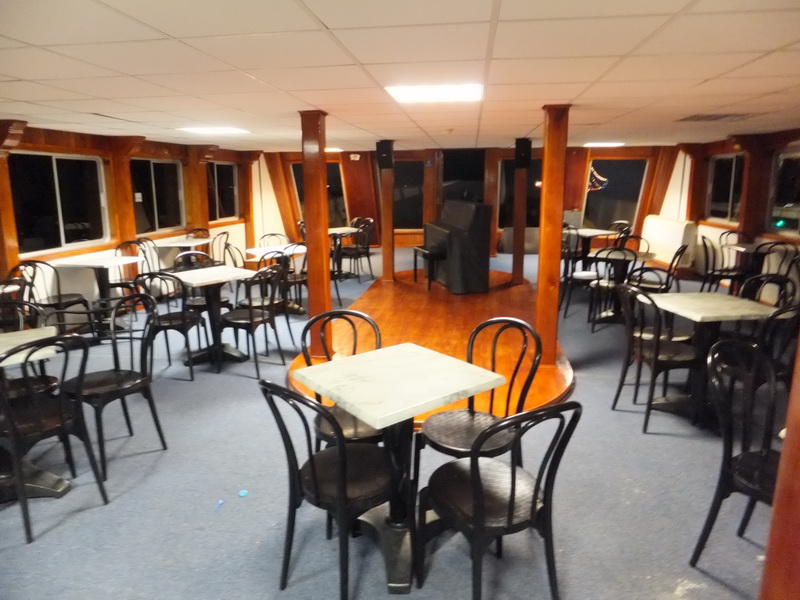 Spacious salon of the Princess boat with marble-top bistro tables, bentwood chairs and a central parquet dance floor