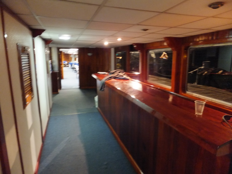 Long polished wood bar running down a paneled passage of the Princess boat toward the dining salon