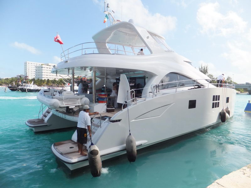 66 ft Sunreef power catamaran Forever docked in turquoise Caribbean water with tender and crew, luxury catamaran charter Cancun