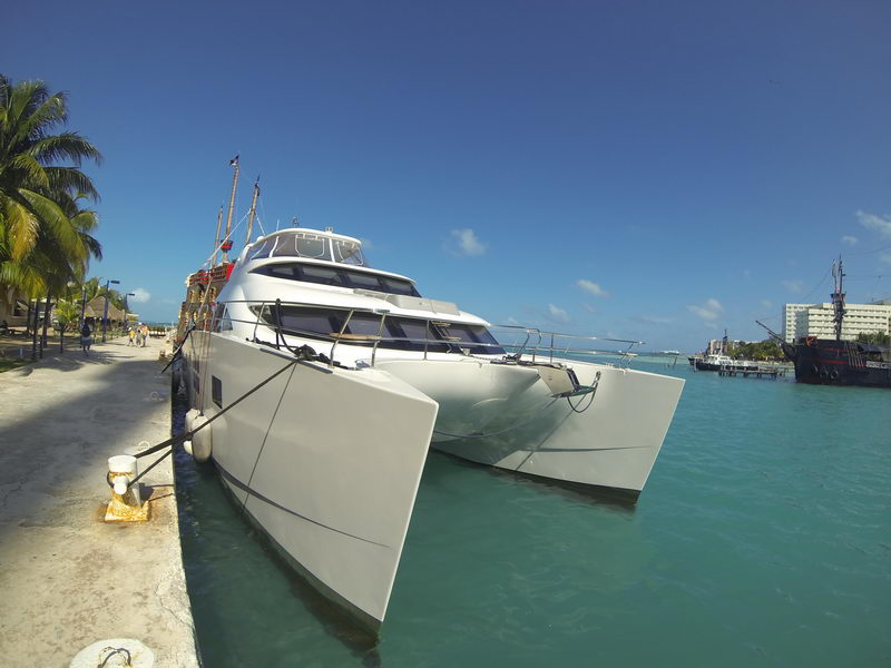 Twin bows of the 66 ft Sunreef luxury power catamaran moored dockside under blue Cancun skies, private catamaran rental