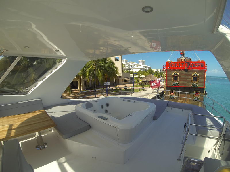 Flybridge jacuzzi of the 66 ft Sunreef luxury catamaran with views of the Cancun waterfront and pirate ship dock