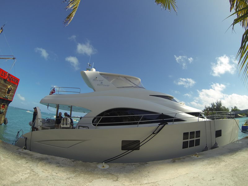 Exterior profile of the Sunreef 60 Power luxury catamaran docked under palm trees and blue Caribbean sky in Cancun