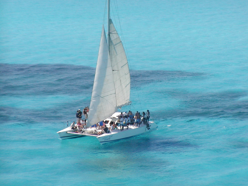 Pasajeros disfrutando de la cubierta del catamarán Tiger en un tour privado de vela desde Cancún a Isla Mujeres