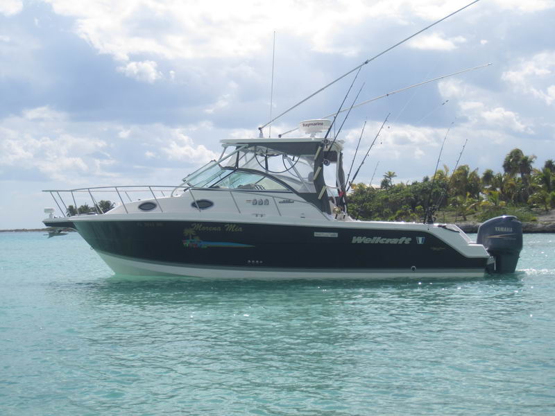 Wellcraft 30 pies Morena Mia anclada en agua turquesa cristalina del Caribe con cañas y motor Yamaha Puerto Aventuras