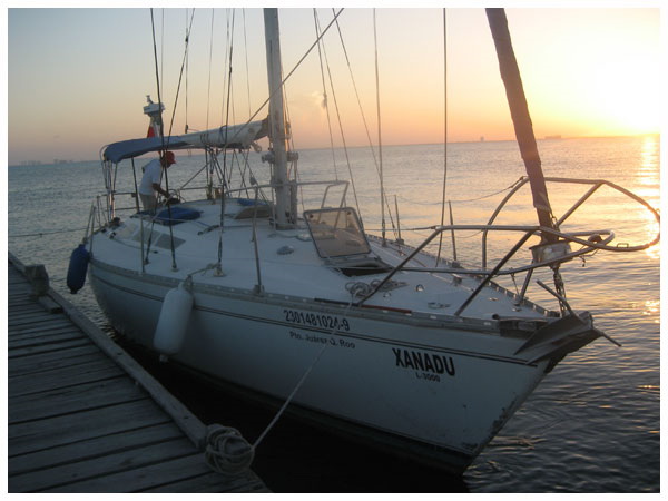 Jeanneau 42 sailboat Xanadu docked at marina pier at golden sunset, Cancun private 